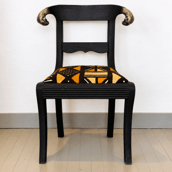 Chaise ancienne en bois noir patiné, tissu africain et têtes de bélier