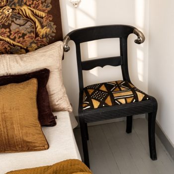 Chaise ancienne en bois noir patiné, tissu africain et têtes de bélier